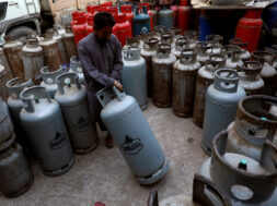 FILE PHOTO: A worker moves a liquid petroleum gas cylinder at a workshop in Karachi,